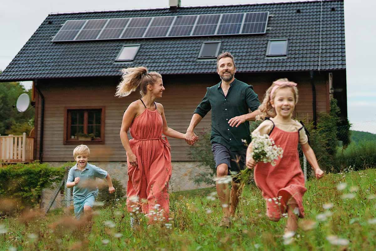 a family running in front of house with solar panels