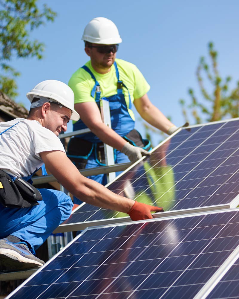 two solar installation experts working on a roof