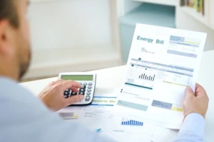 solar installation man rechecking energy bill on a calculator