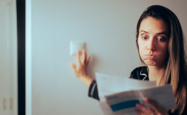 Northern VA woman checking monthly electricity bill turning out the lights at home