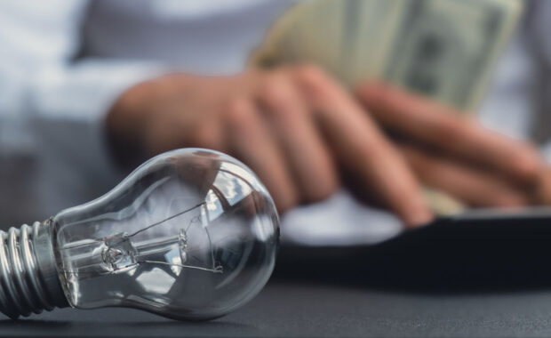 Maryland homeowner's hands counting expenses bills on electricity banknotes of dollar cash accounting on calculator