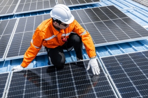 Worker Installing Solar Panel on Industry Roof