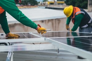 Workers Tightening Nuts After Installing Solar Panels