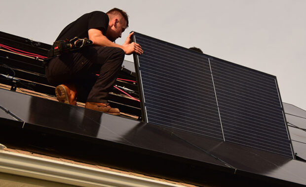 Close-up of solar installer tightening final clamps on a residential solar array, representing the completed installation required to claim the 2025 Residential Clean Energy Credit.