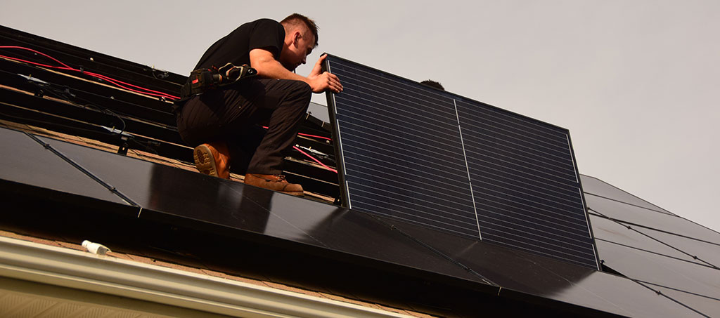 Close-up of solar installer tightening final clamps on a residential solar array, representing the completed installation required to claim the 2025 Residential Clean Energy Credit.