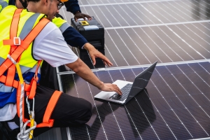 Solar Engineer Working on Laptop to Assess Energy Production