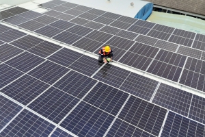 Worker Conducting Maintenance on Solar Panels on Commercial Building