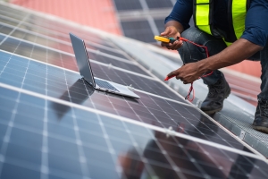 Service Engineer Checking Solar Panel on Roof for Maintenance
