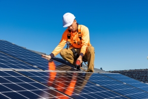 Local Worker Installing Solar Panel on House Rooftop Near Maryland