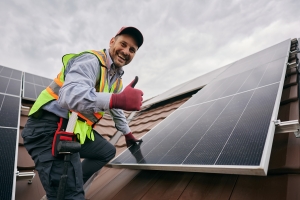 Local Worker Showing Thumb Up While Installing Solar Panels on Roof