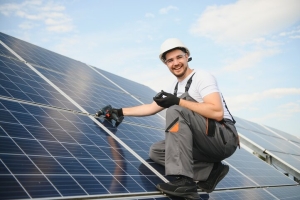 Smiling Local Solar Panel Installer on a Residential Building Rooftop