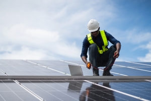 Service Engineer Inspecting Solar Panels on a Roof for Routine Maintenance and Damage Checks